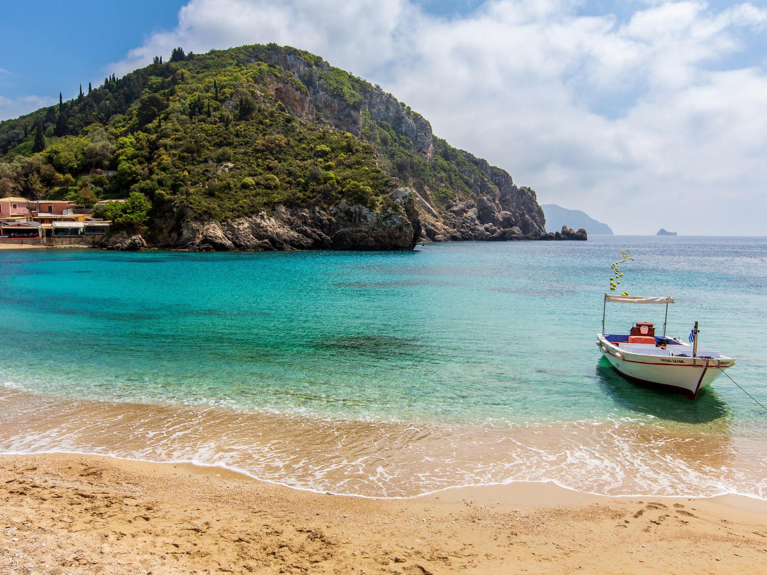 Small boat on a sandy beach of Corfu Island