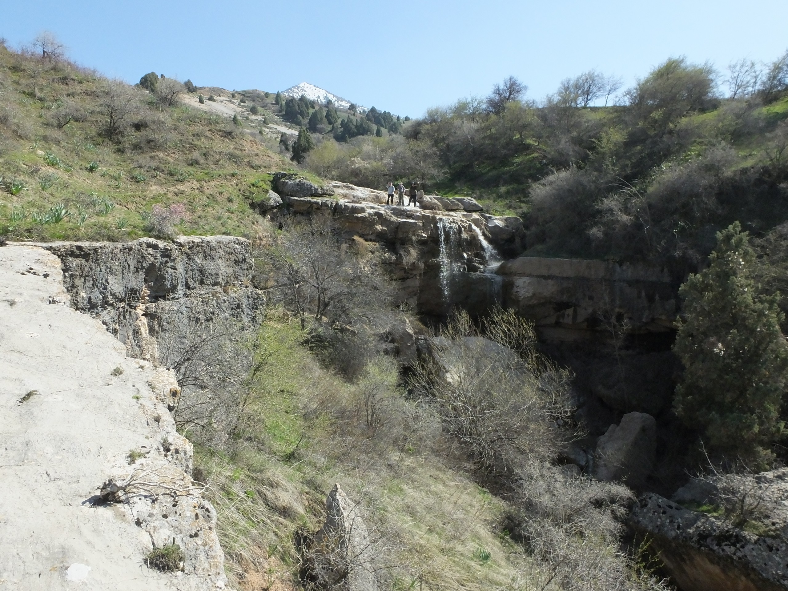 Three hikers standing on the waterfall