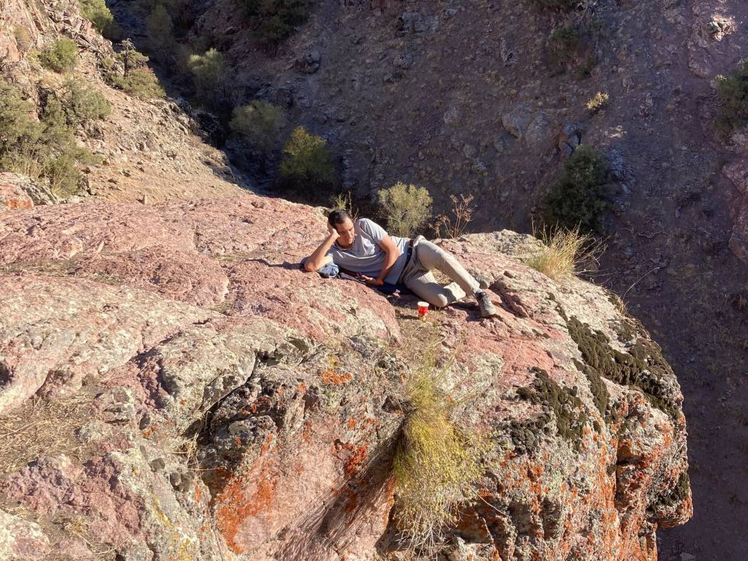 Hiker resting on a cliff in Uzbekistan