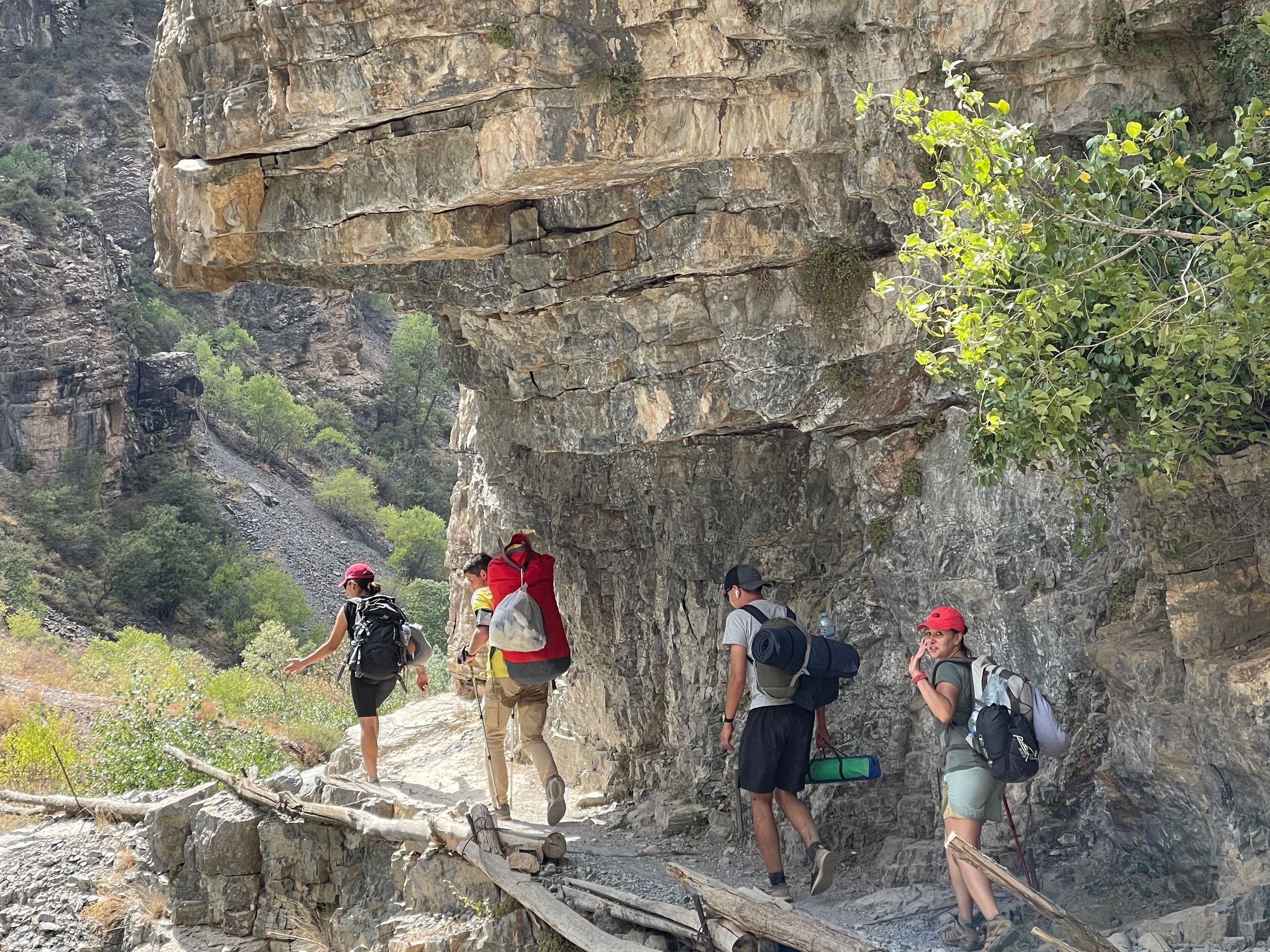 Group of hikers walking along the rockwall in Uzbekistan