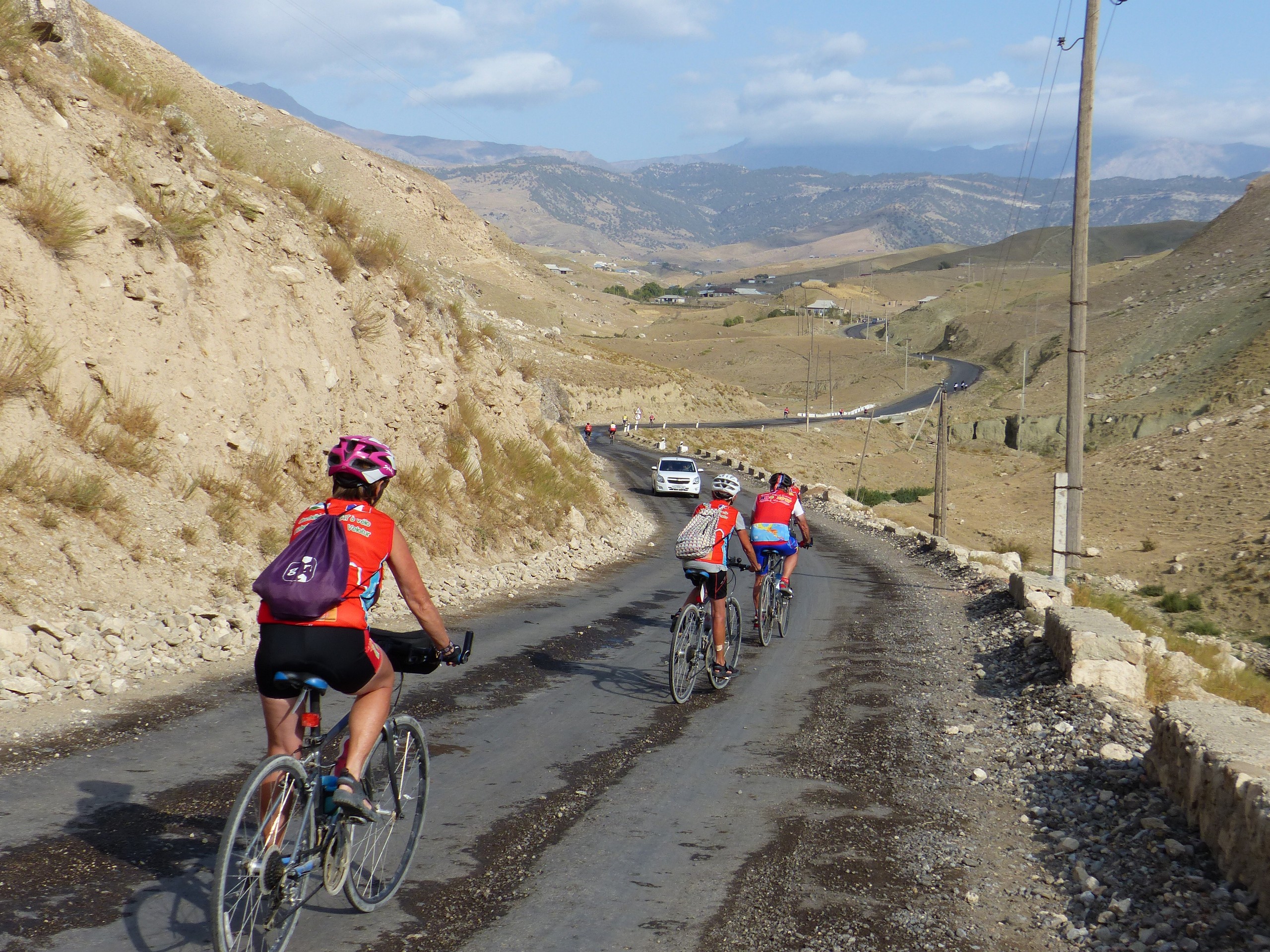 Group of bikers riding down the hill in Uzbek Countryside