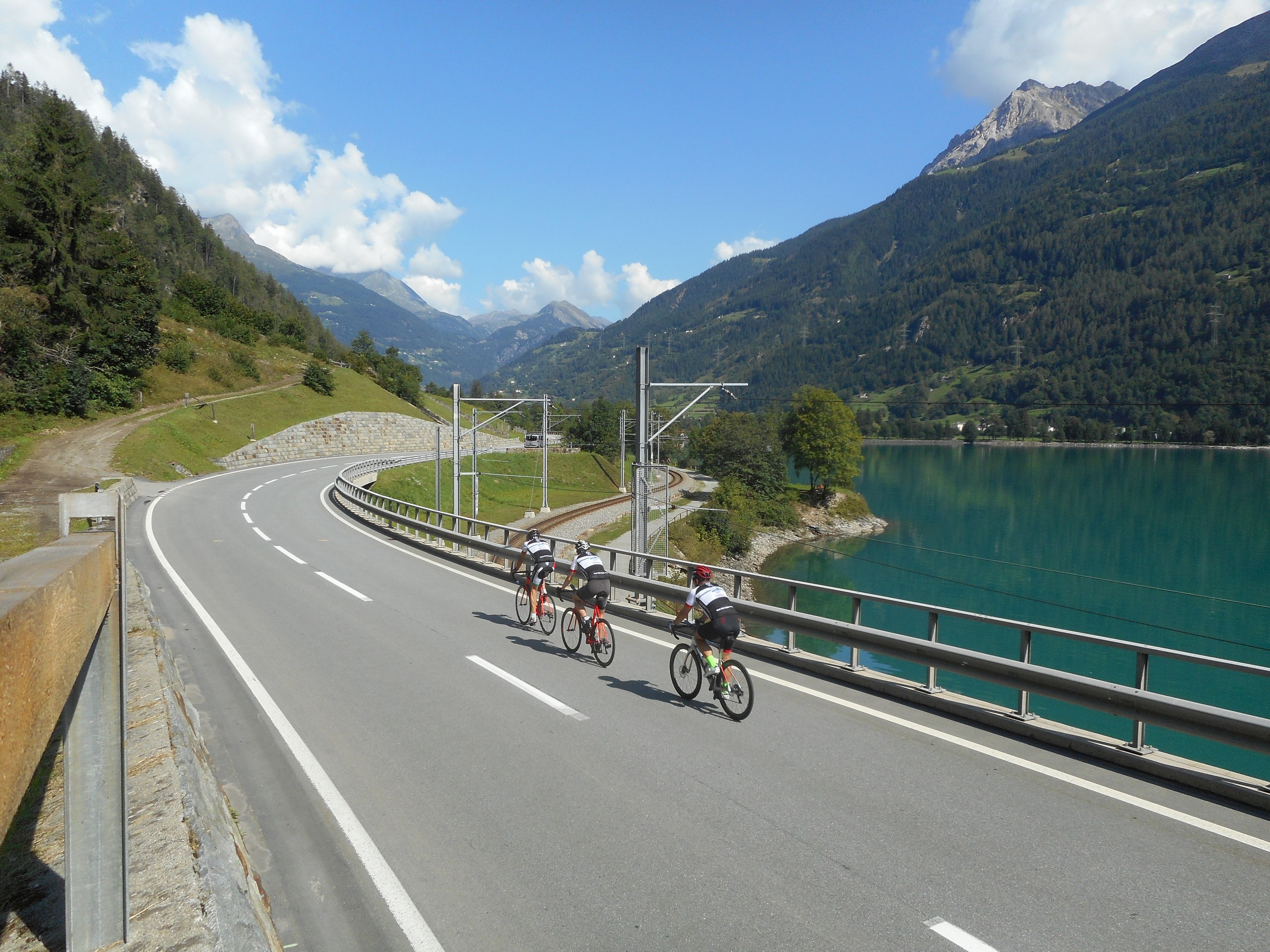 Three cyclists biking along the lake in Northern Italy