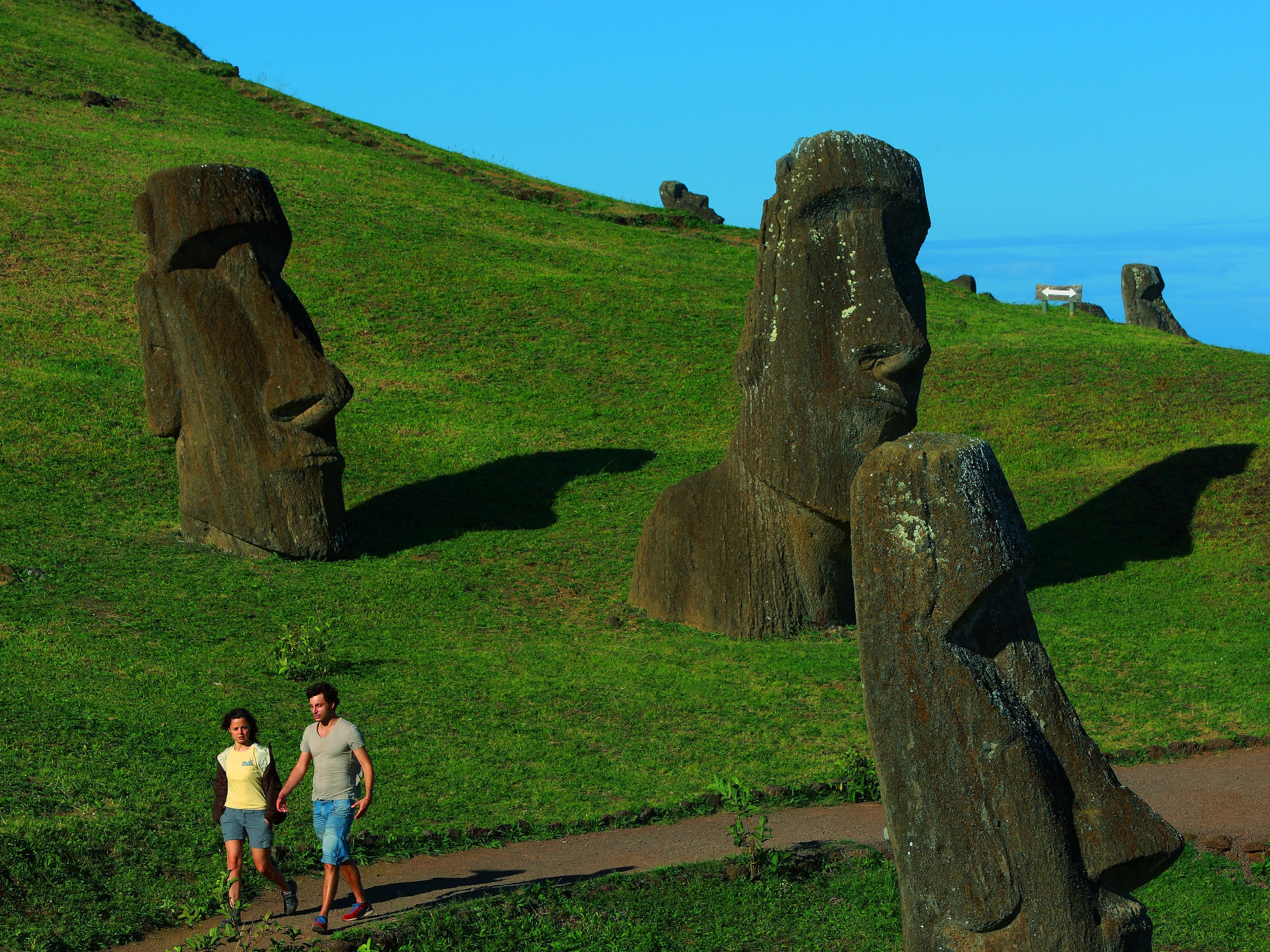 Couple walking among the stone figures of the Easter Island