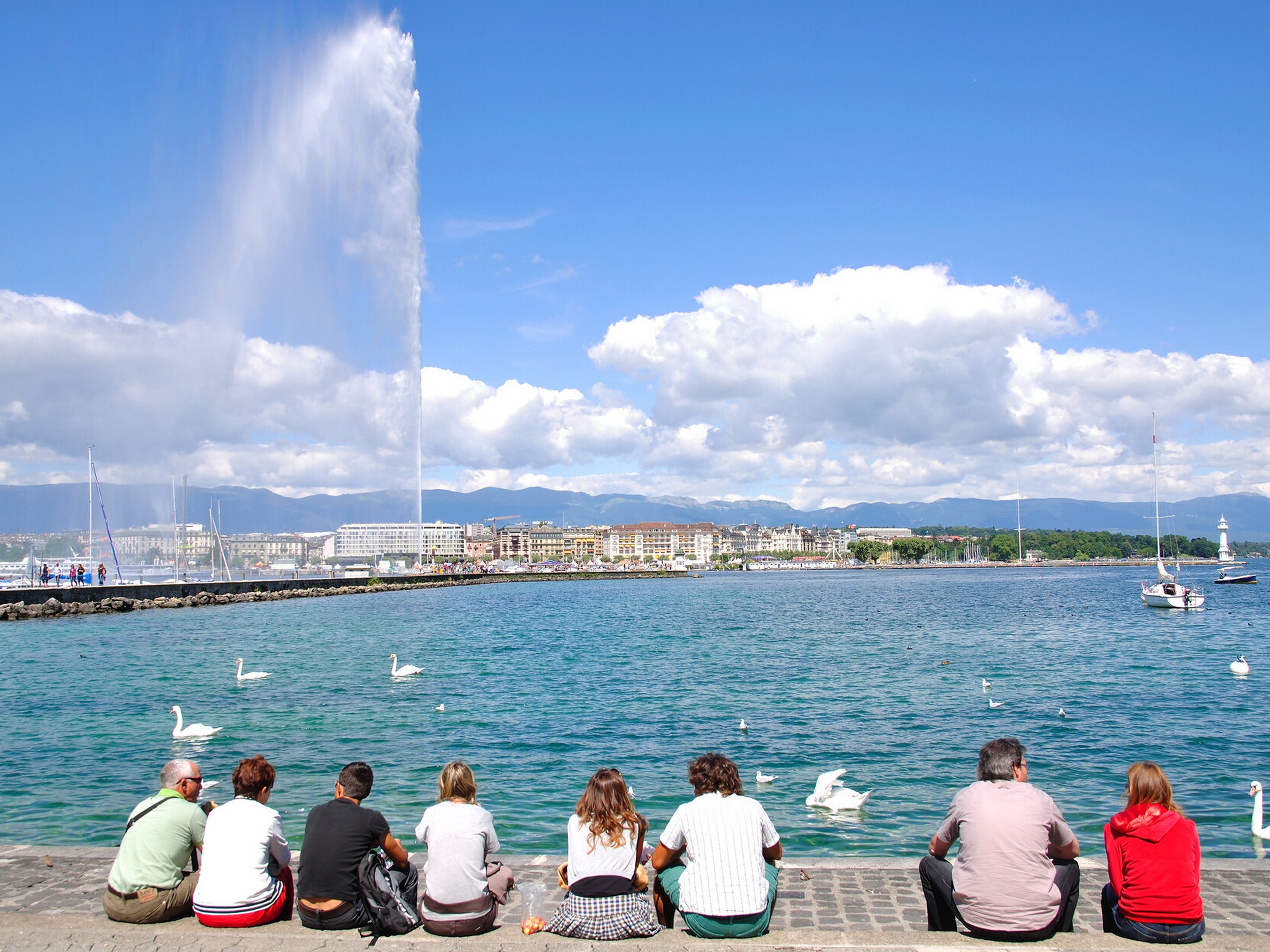 Group of cyclists enjoying the break near a fountain in Alps