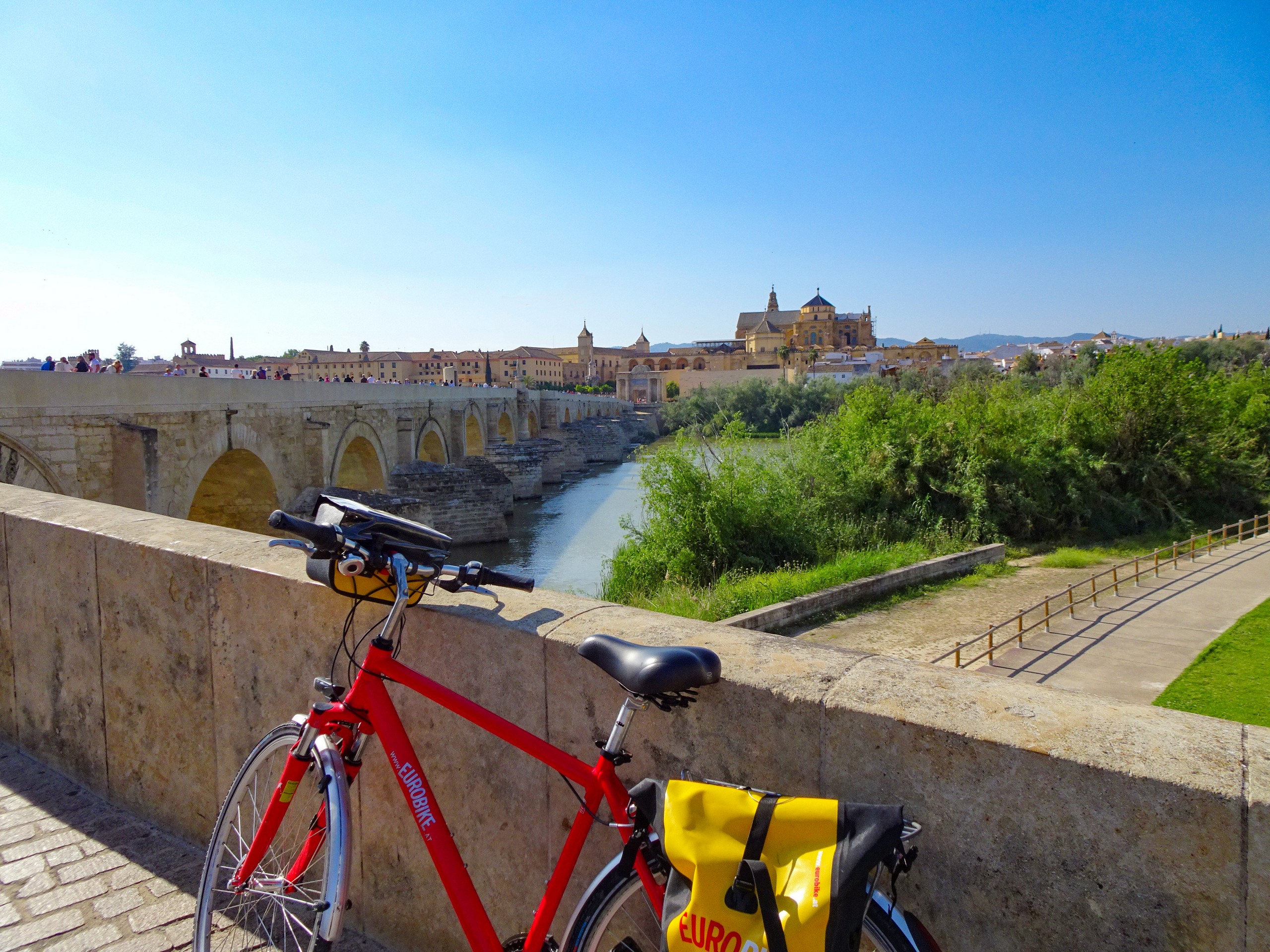 Bike parked in front of yellow stone bridge