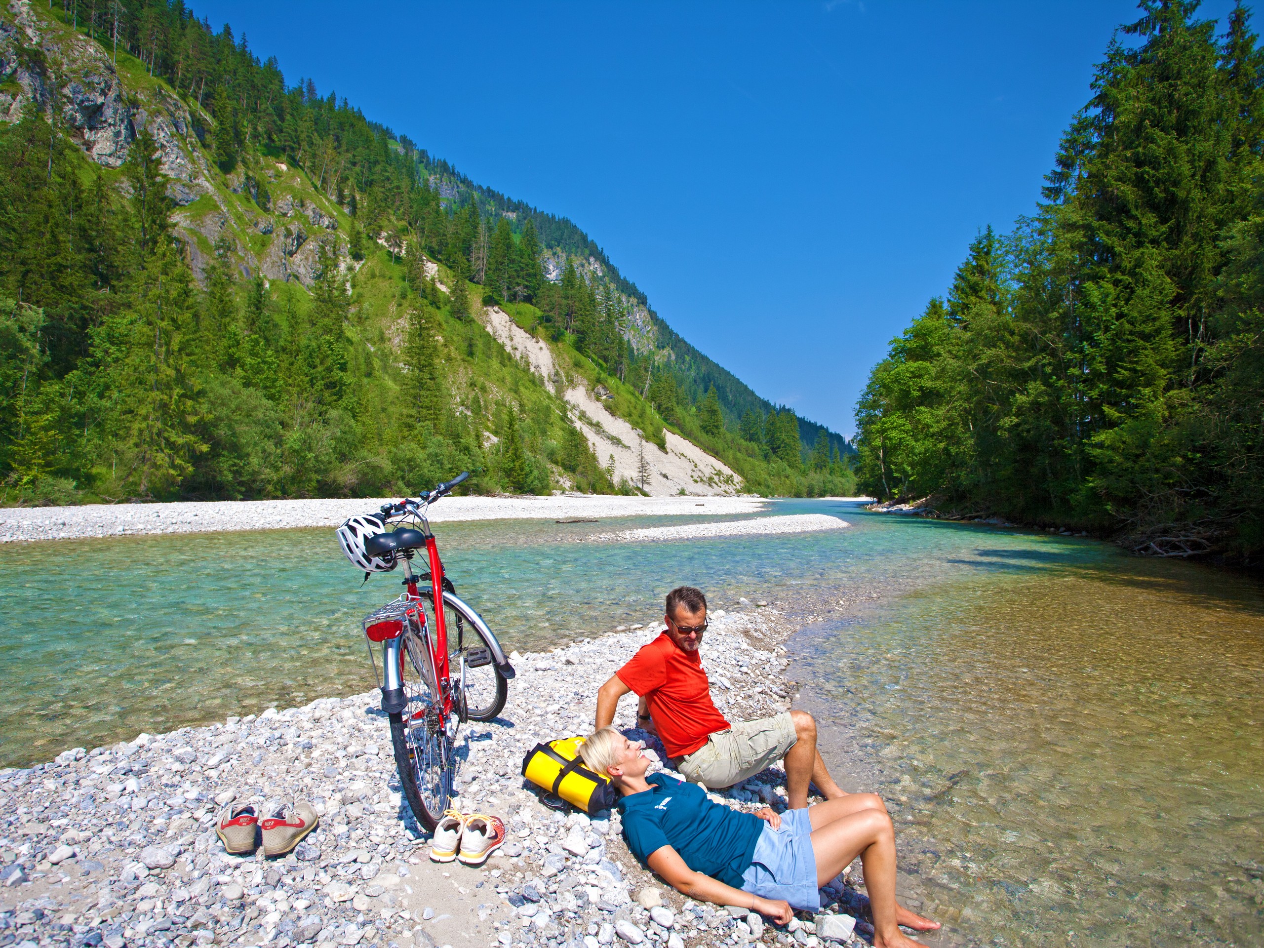 Couple resting near the river in Bavarian mountains